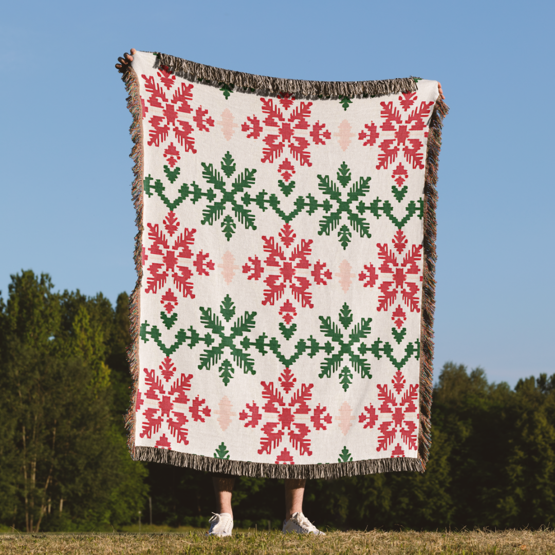 a woman standing in a field holding a quilt
