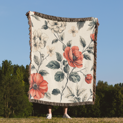 a woman standing in a field holding a blanket with flowers on it