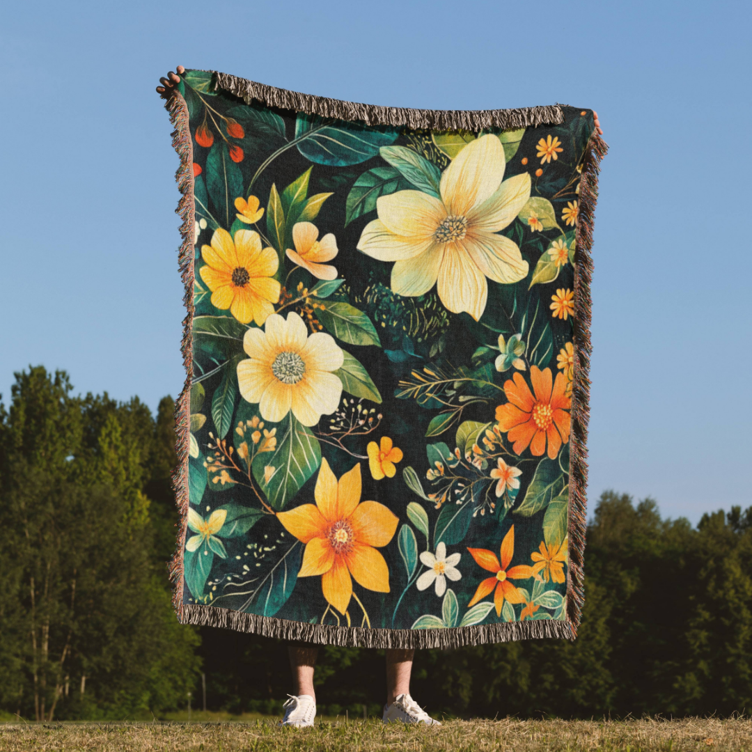 a woman standing in a field holding a blanket with flowers on it