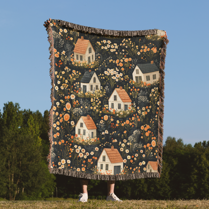 a woman holding a quilt with houses on it