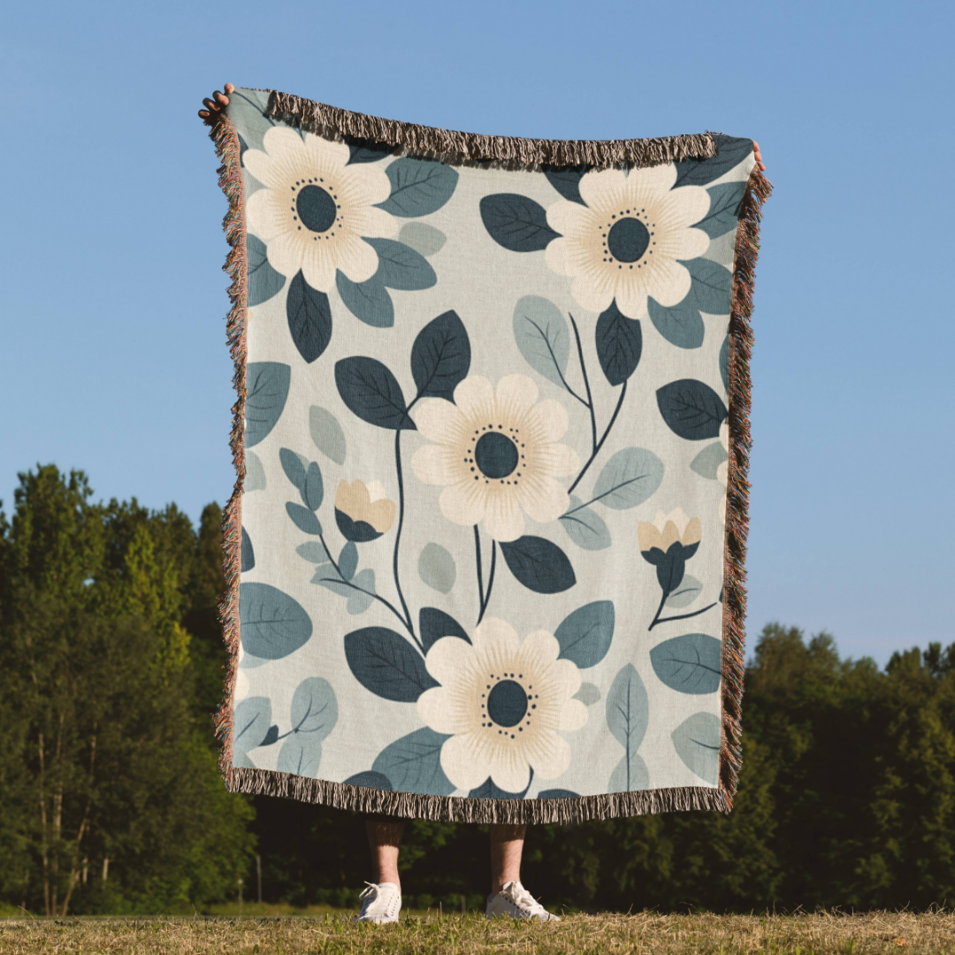 a person standing in a field holding a blanket with flowers on it