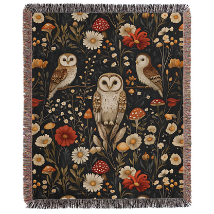 a tapestry with two owls and flowers on a black background