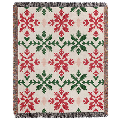 a red and green blanket with snowflakes on it