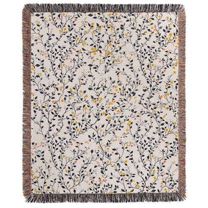 a white blanket with yellow and black flowers on it