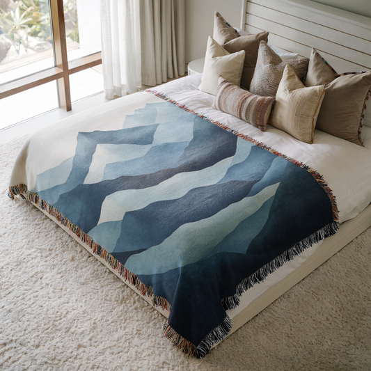 a bed with a blue and white comforter on top of it