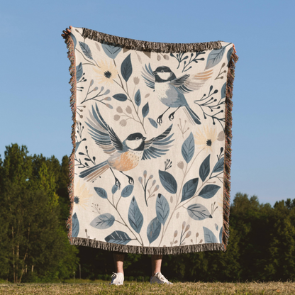 a woman standing in a field holding a blanket with birds on it